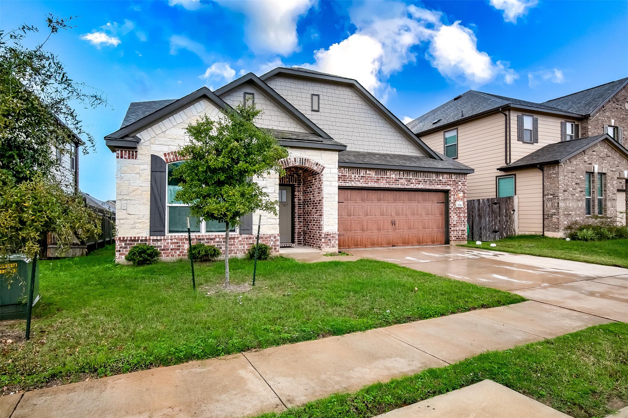 7616 Groundhog Way Austin, TX 78744 - Photo 2 of 34 a front view of a house with a yard table and chairs