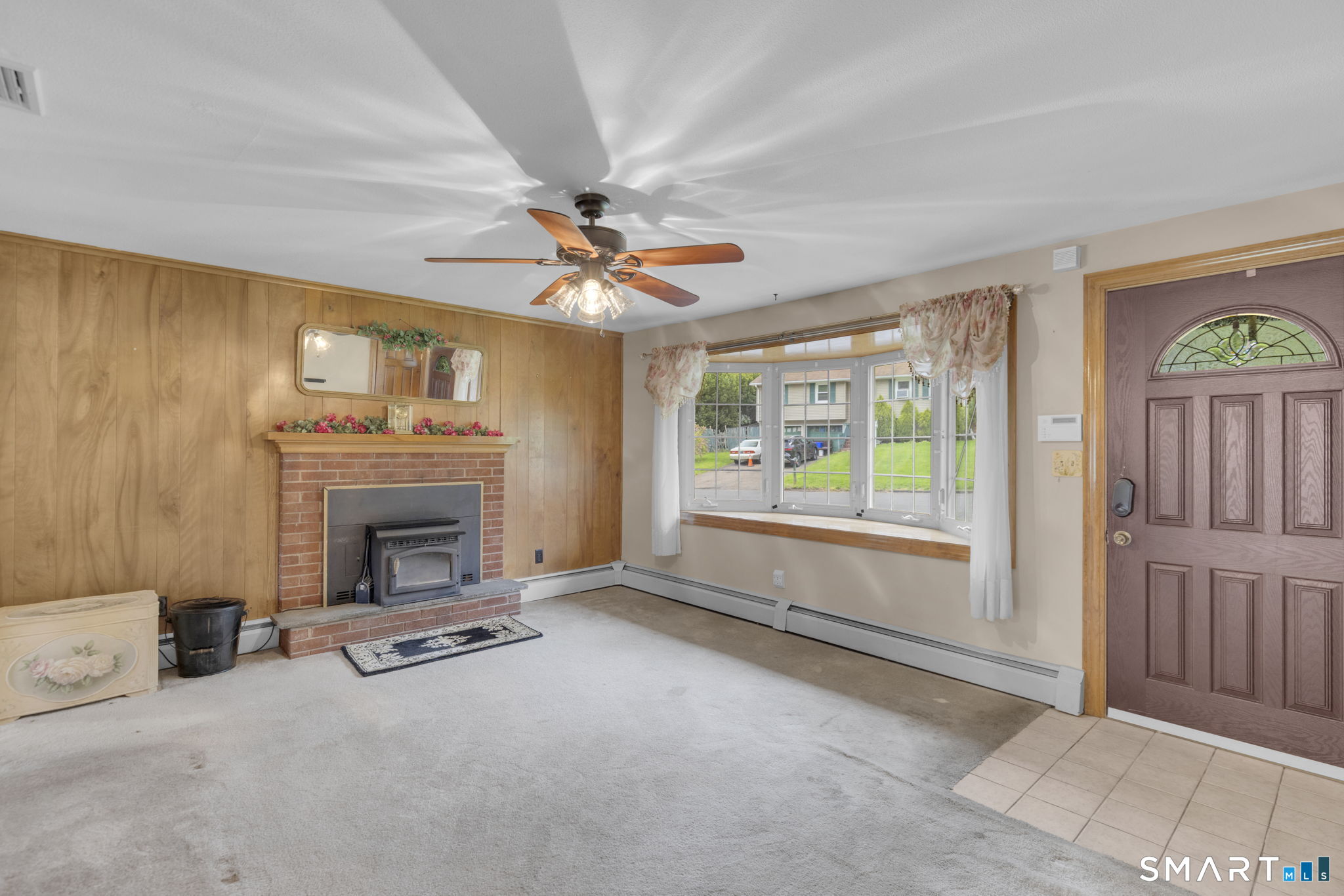 102 Wayne Lane Meriden, CT 06450 - Photo 3 of 36 a view of a livingroom with a fireplace a ceiling fan and windows
