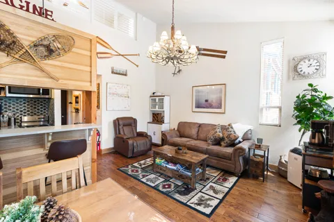 a living room with furniture a chandelier and a fireplace