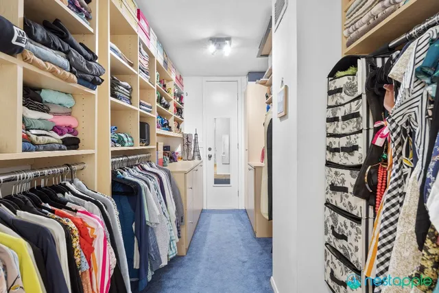 a view of walk in closet with clothes and shoes