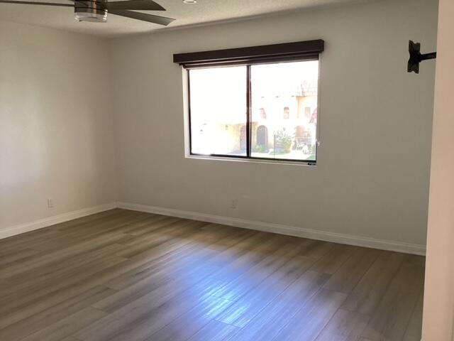 228 Eagle Lane Palmdale, CA 93551 - Photo 13 of 17 an empty room with wooden floor and windows