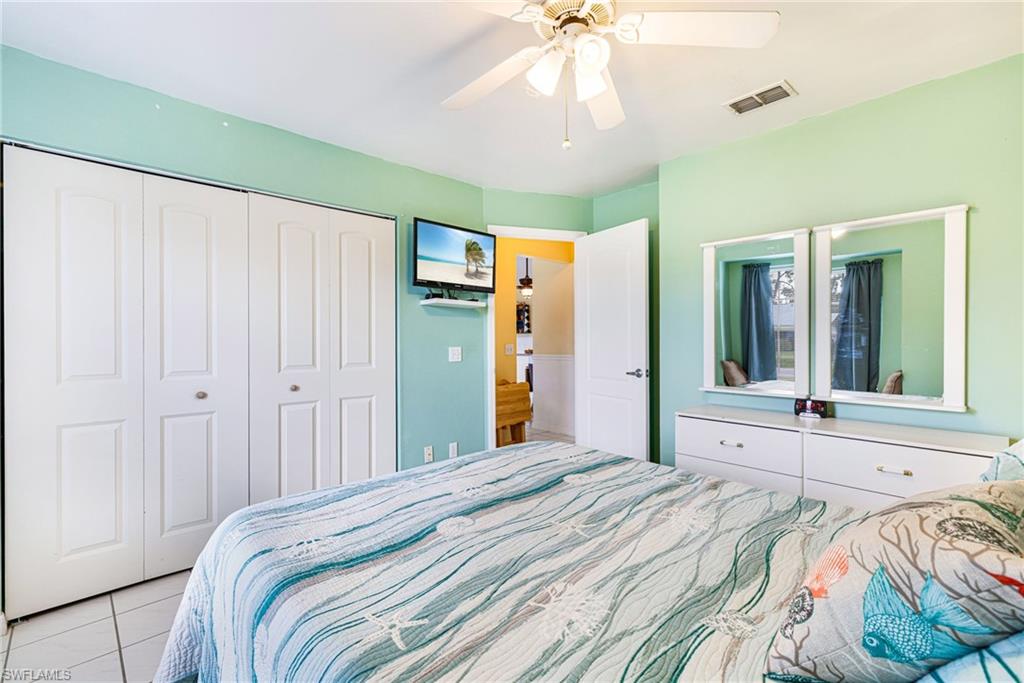 8241 Albatross Road Fort Myers, FL 33967 - Photo 22 of 48 a bedroom with a large bed and a chandelier