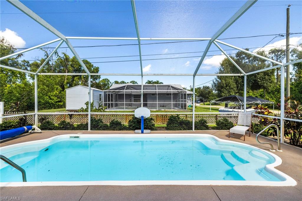 8241 Albatross Road Fort Myers, FL 33967 - Photo 27 of 48 a view of a swimming pool with lawn chairs and a big yard