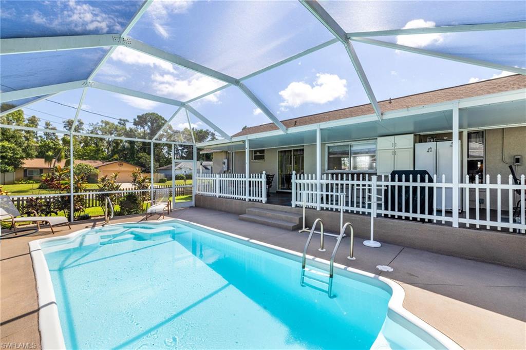 8241 Albatross Road Fort Myers, FL 33967 - Photo 29 of 48 a view of a patio with a dining table and chairs under an umbrella
