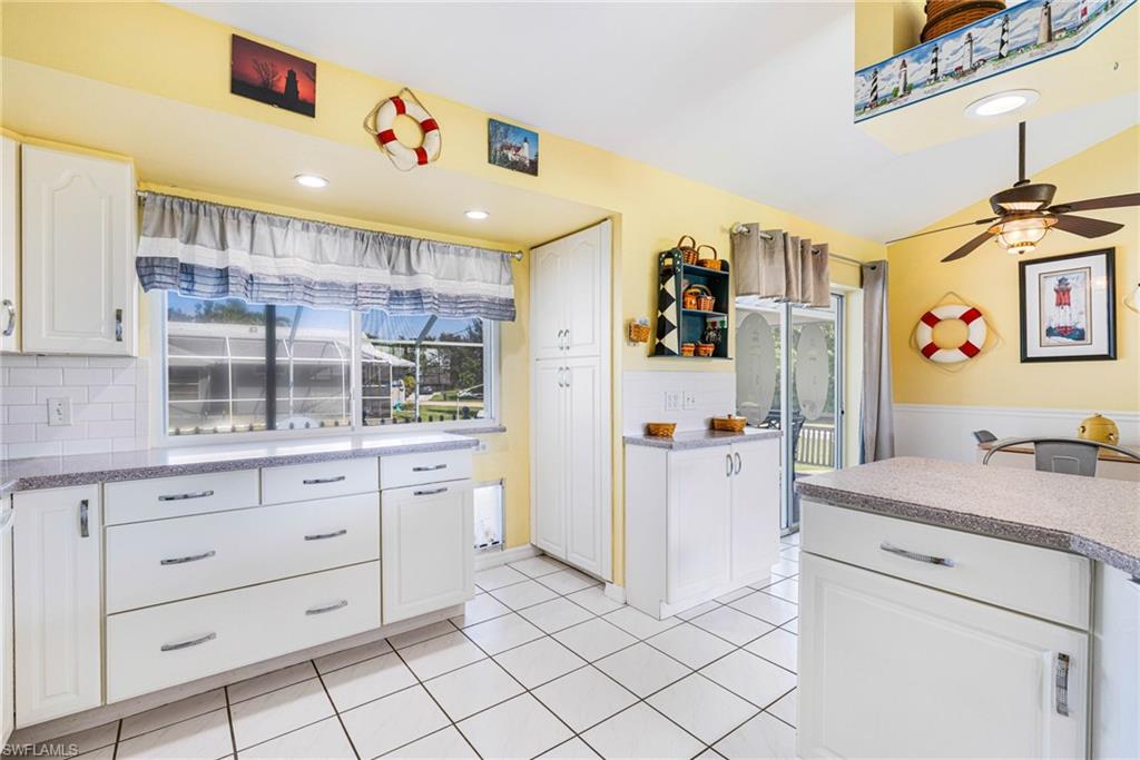 8241 Albatross Road Fort Myers, FL 33967 - Photo 7 of 48 a kitchen with a refrigerator and countertop cabinets