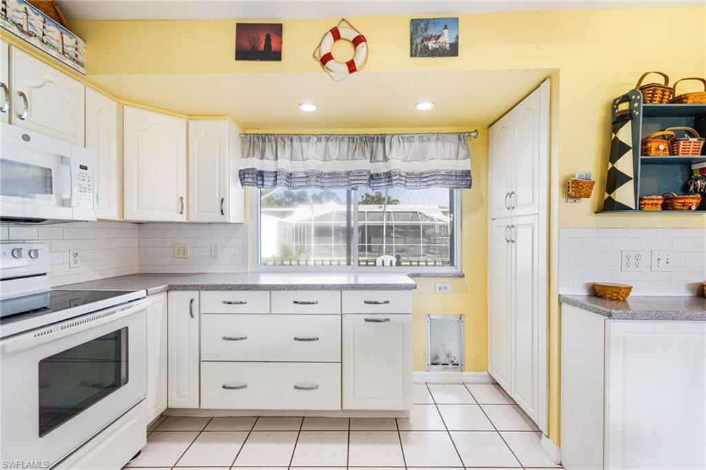 8241 Albatross Road Fort Myers, FL 33967 - Photo 8 of 48 a kitchen with white cabinets and appliances