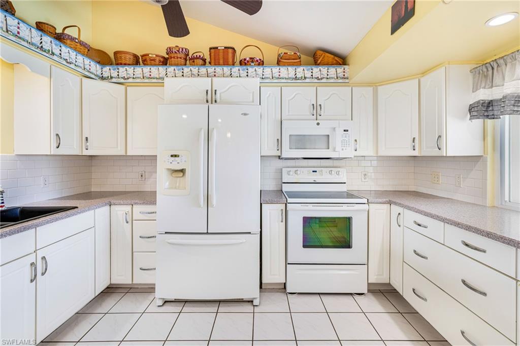 8241 Albatross Road Fort Myers, FL 33967 - Photo 9 of 48 a kitchen with cabinets and white appliances