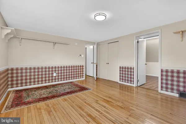 a view of empty room with wooden floor