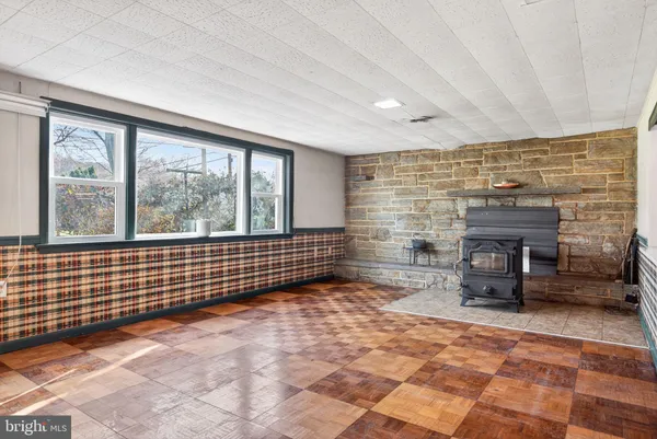 a view of an empty room with a fireplace and a large window