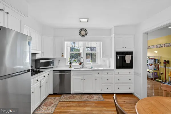 a kitchen with granite countertop a refrigerator and a stove top oven