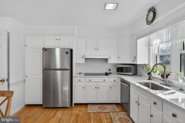 a kitchen with a refrigerator sink and white cabinets
