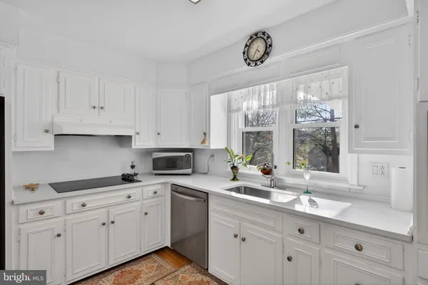 a kitchen with appliances cabinets a large window and sink