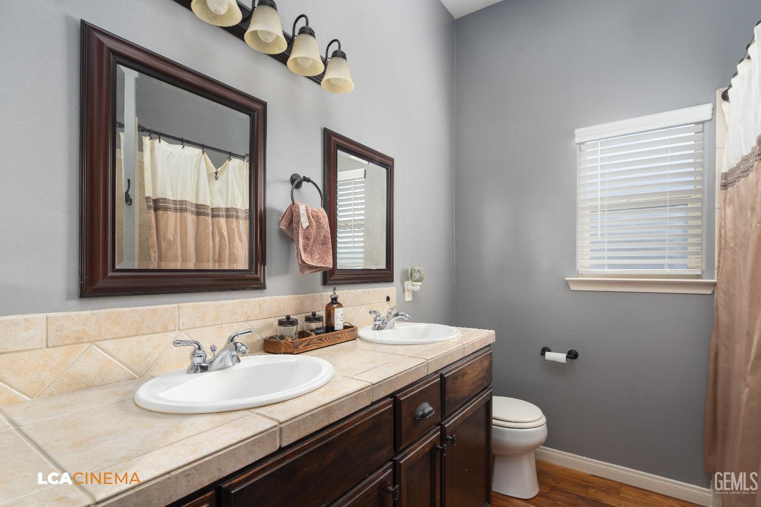 Undisclosed Address Shafter, CA 93263 - Photo 12 of 25 a bathroom with a granite countertop toilet sink and mirror