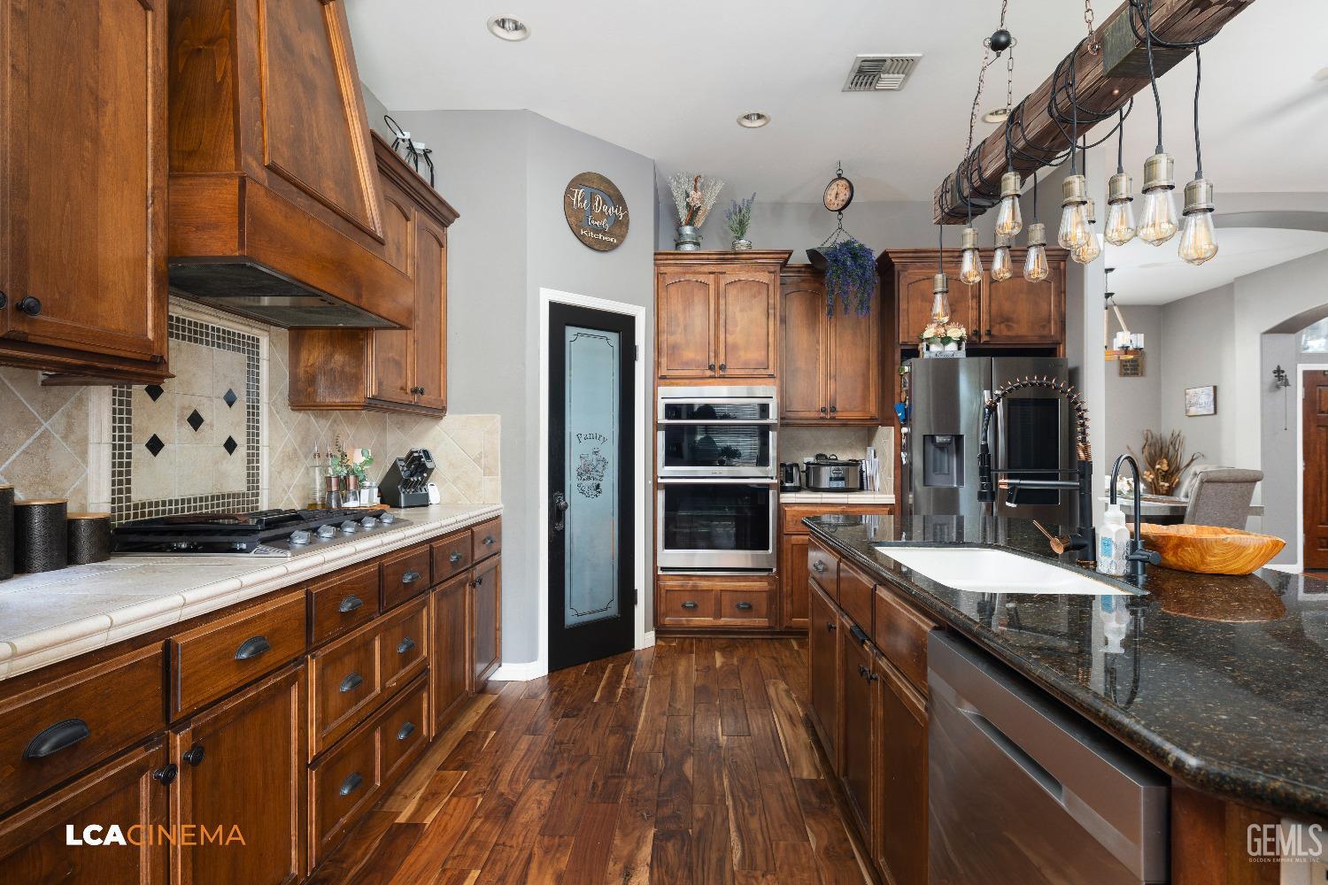 Undisclosed Address Shafter, CA 93263 - Photo 6 of 25 a kitchen with stainless steel appliances granite countertop a sink a stove and a wooden floors