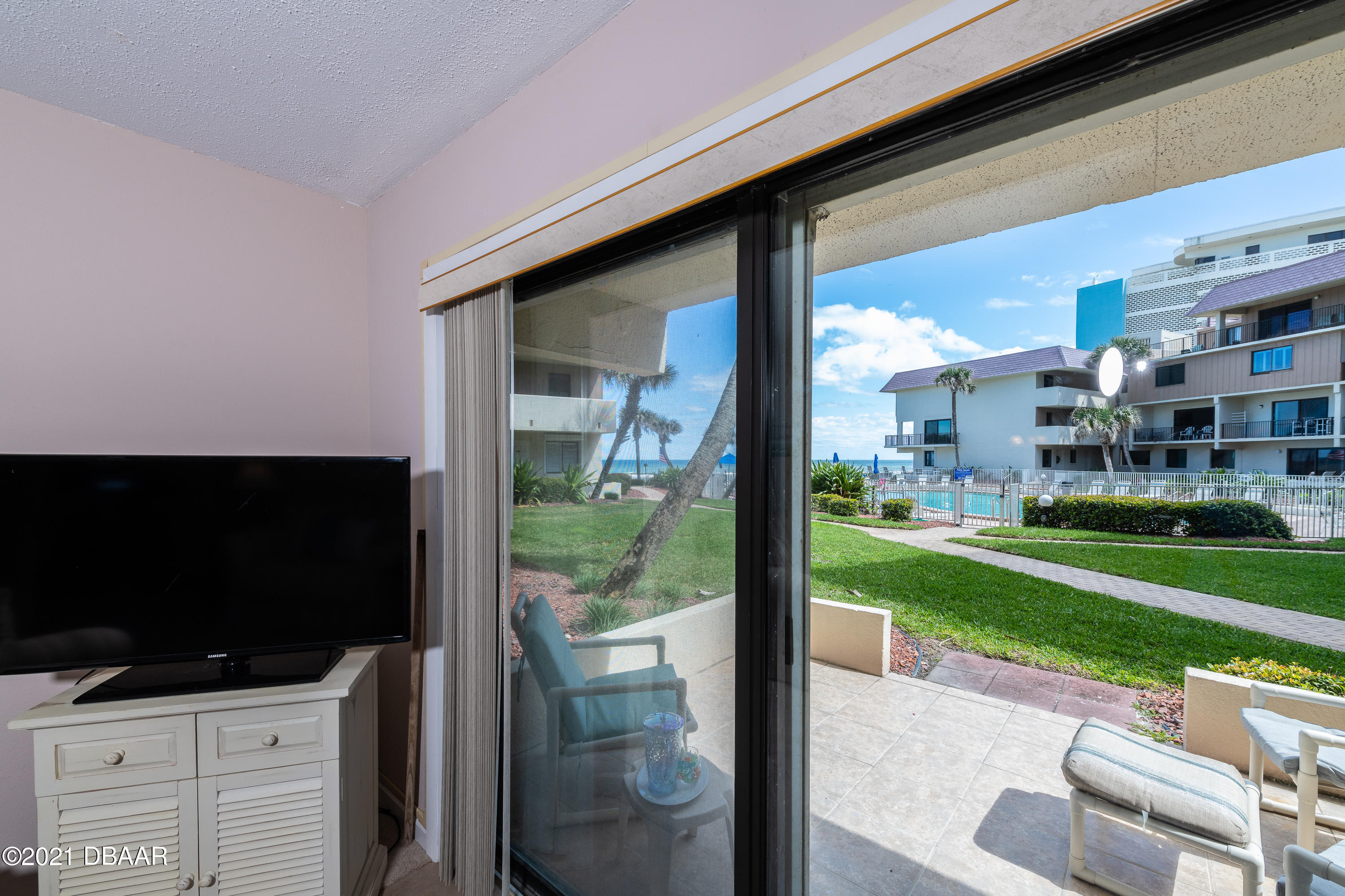 935 Ocean Shore Boulevard, Unit 110 Ormond Beach, FL 32176 - Photo 17 of 21 a room with furniture and a flat screen tv