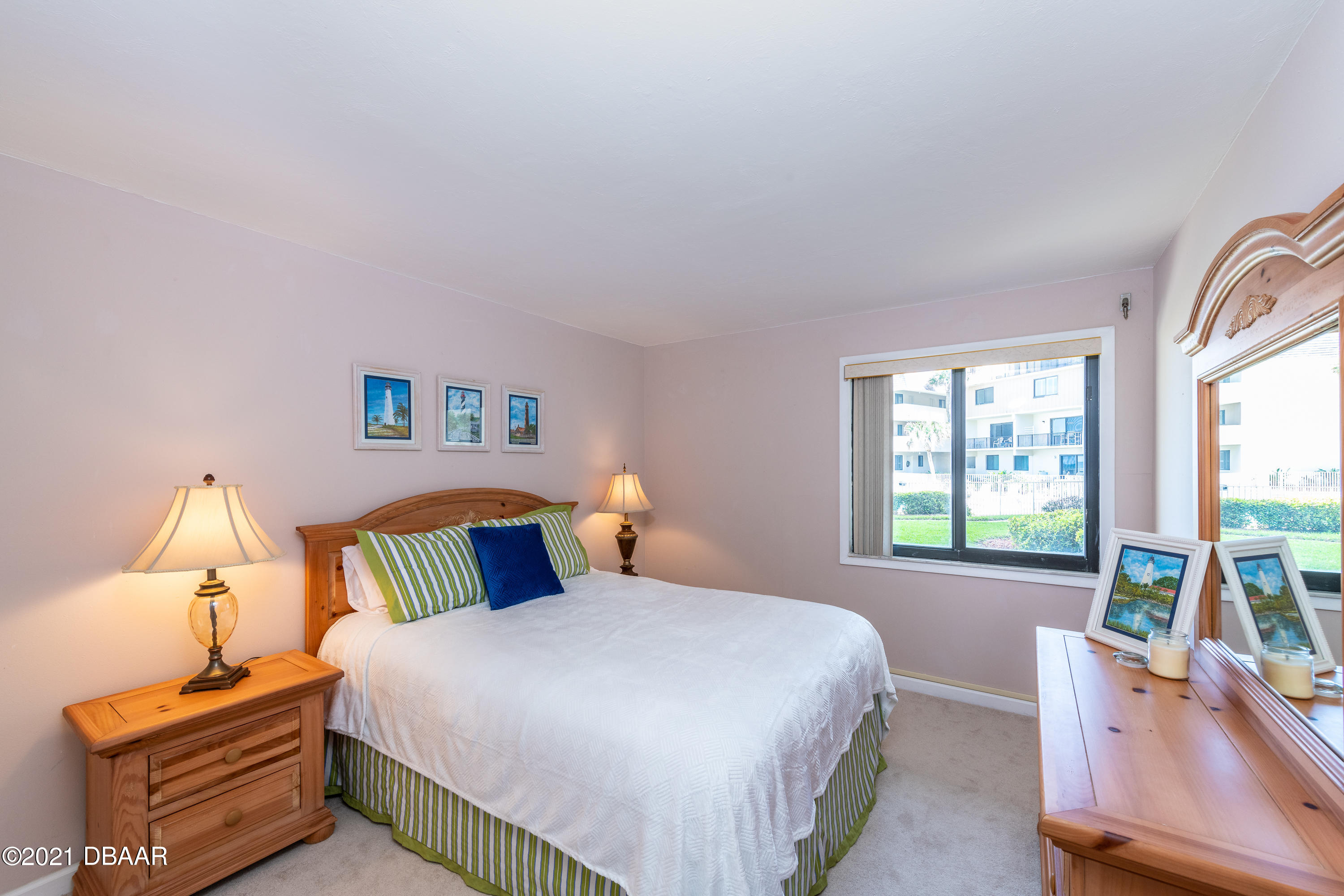 935 Ocean Shore Boulevard, Unit 110 Ormond Beach, FL 32176 - Photo 7 of 21 a bedroom with a bed and wooden floor