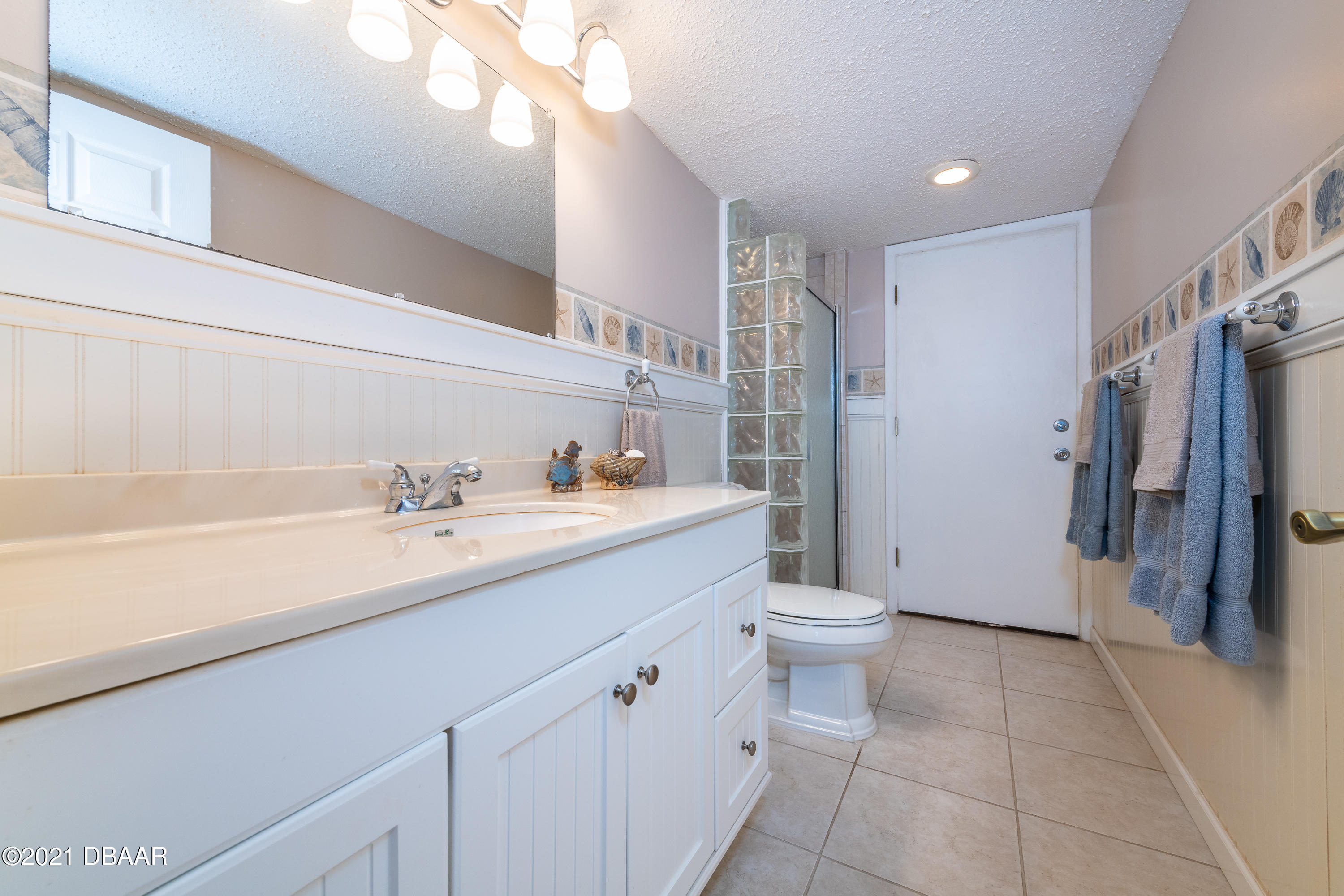 935 Ocean Shore Boulevard, Unit 110 Ormond Beach, FL 32176 - Photo 8 of 21 a bathroom with a double vanity sink toilet and shower