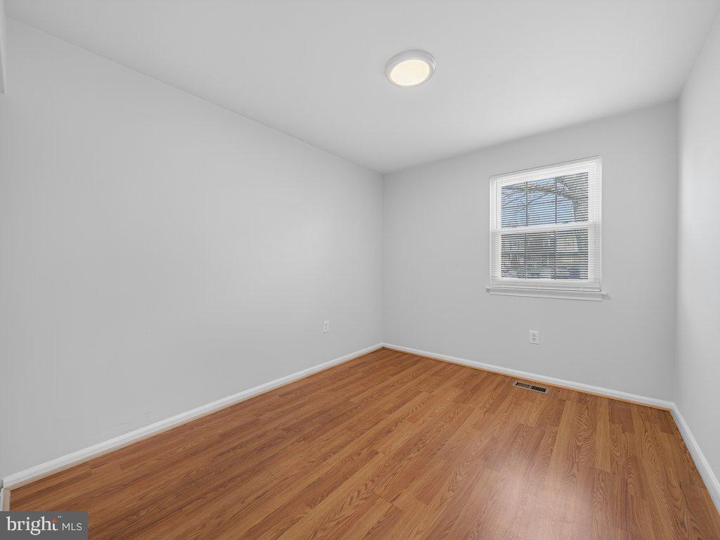3827 Gawayne Terrace Silver Spring, MD 20906 - Photo 28 of 45 a view of an empty room with wooden floor and a window