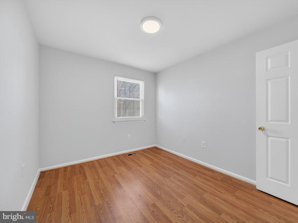 3827 Gawayne Terrace Silver Spring, MD 20906 - Photo 29 of 45 an empty room with wooden floor and windows