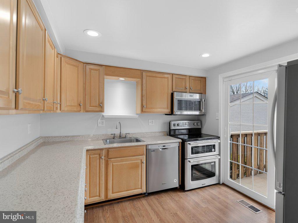 3827 Gawayne Terrace Silver Spring, MD 20906 - Photo 8 of 45 a kitchen with cabinets stainless steel appliances and wooden floor