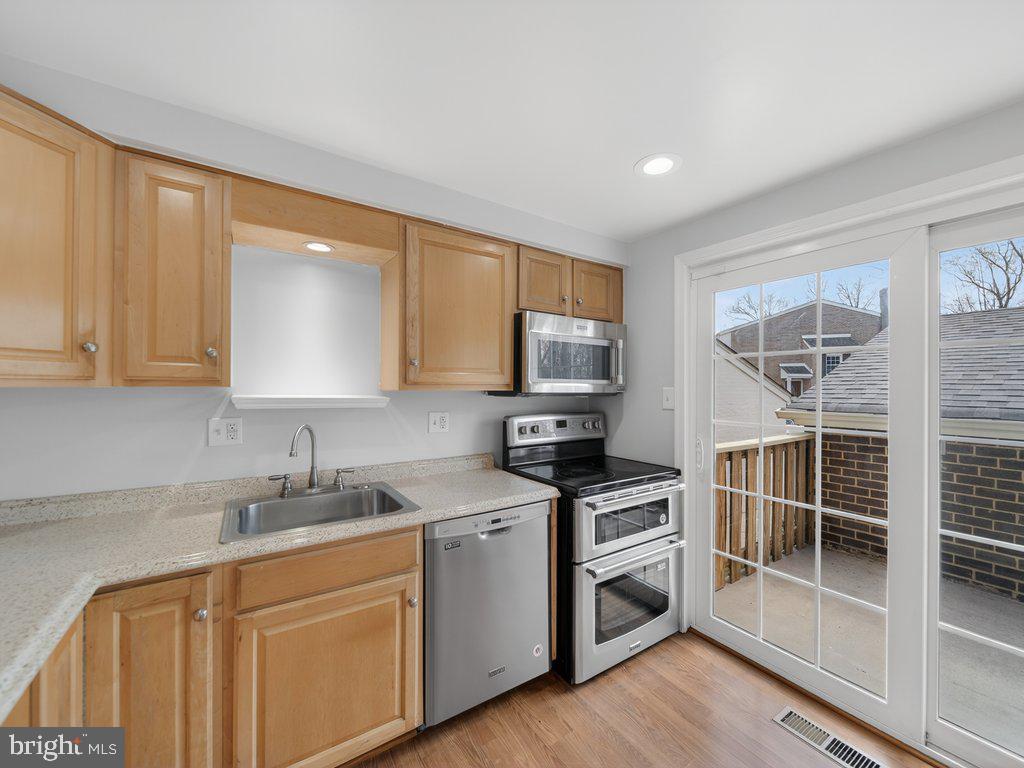 3827 Gawayne Terrace Silver Spring, MD 20906 - Photo 10 of 45 a kitchen with stainless steel appliances a stove a sink and a microwave