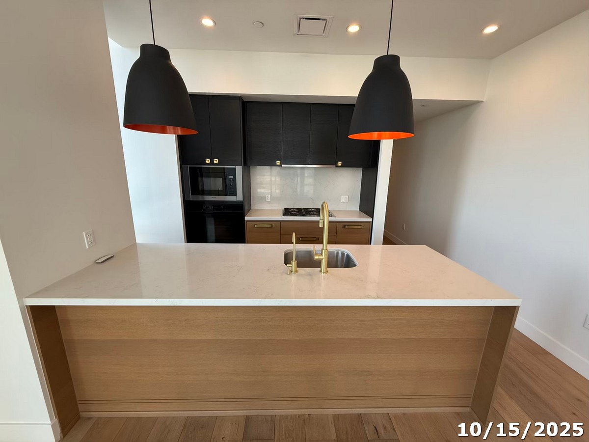 70 Rainey Street, Unit 2907 Austin, TX 78701 - Photo 3 of 15 a close view of kitchen island with a sink a wooden floor and a cabinet
