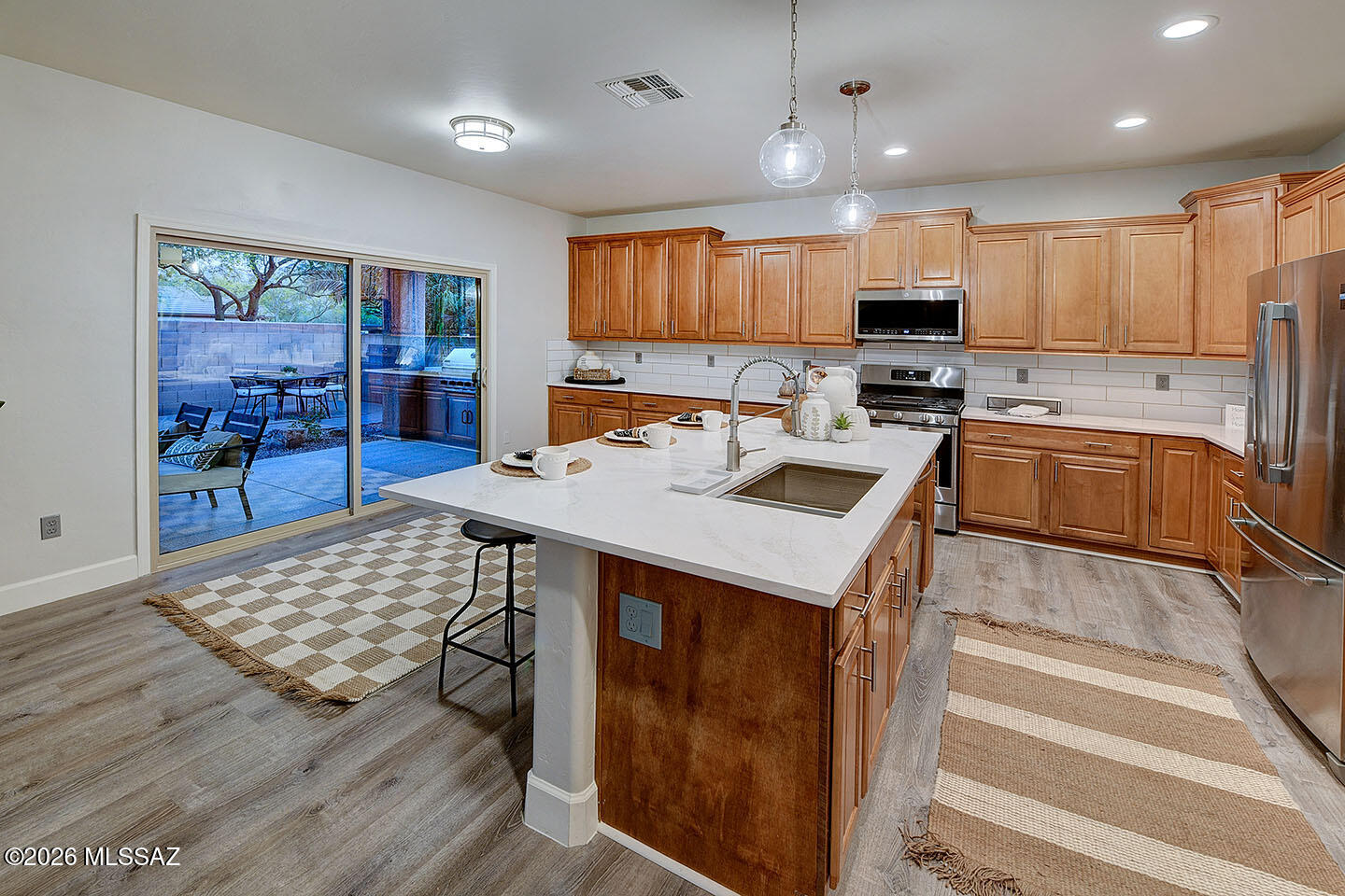 13464 North Piemonte Way Oro Valley, AZ 85755 - Photo 11 of 33 a kitchen with stainless steel appliances granite countertop a stove top oven a sink dishwasher and a refrigerator with wooden floor