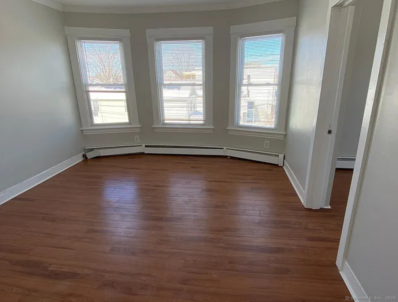 1389 Pembroke Street, Unit 1 Bridgeport, CT 06608 - Photo 1 of 3 an empty room with wooden floor and windows