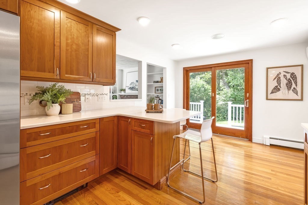 21 Vanderbelt Road Acton, MA 01720 - Photo 8 of 36 a kitchen with granite countertop wooden cabinets and dining table chairs