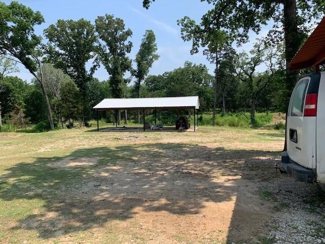 12046 Center Street, Unit 200 Quinlan, TX 75474 - Photo 3 of 9 a backyard of a house with table and chairs under an umbrella