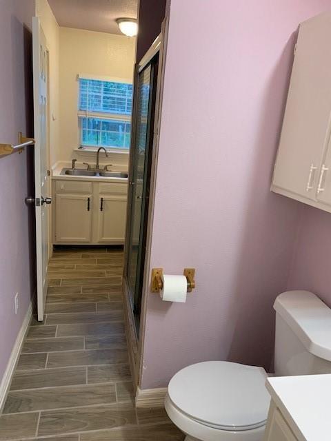 12046 Center Street, Unit 200 Quinlan, TX 75474 - Photo 7 of 9 a bathroom with a sink a toilet and shower