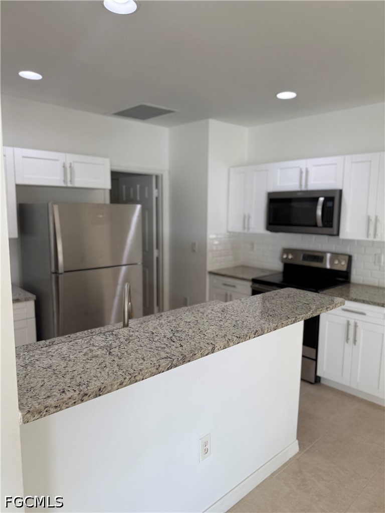 2916 7th Street Southwest Lehigh Acres, FL 33976 - Photo 8 of 19 a kitchen with stainless steel appliances granite countertop a refrigerator and a sink