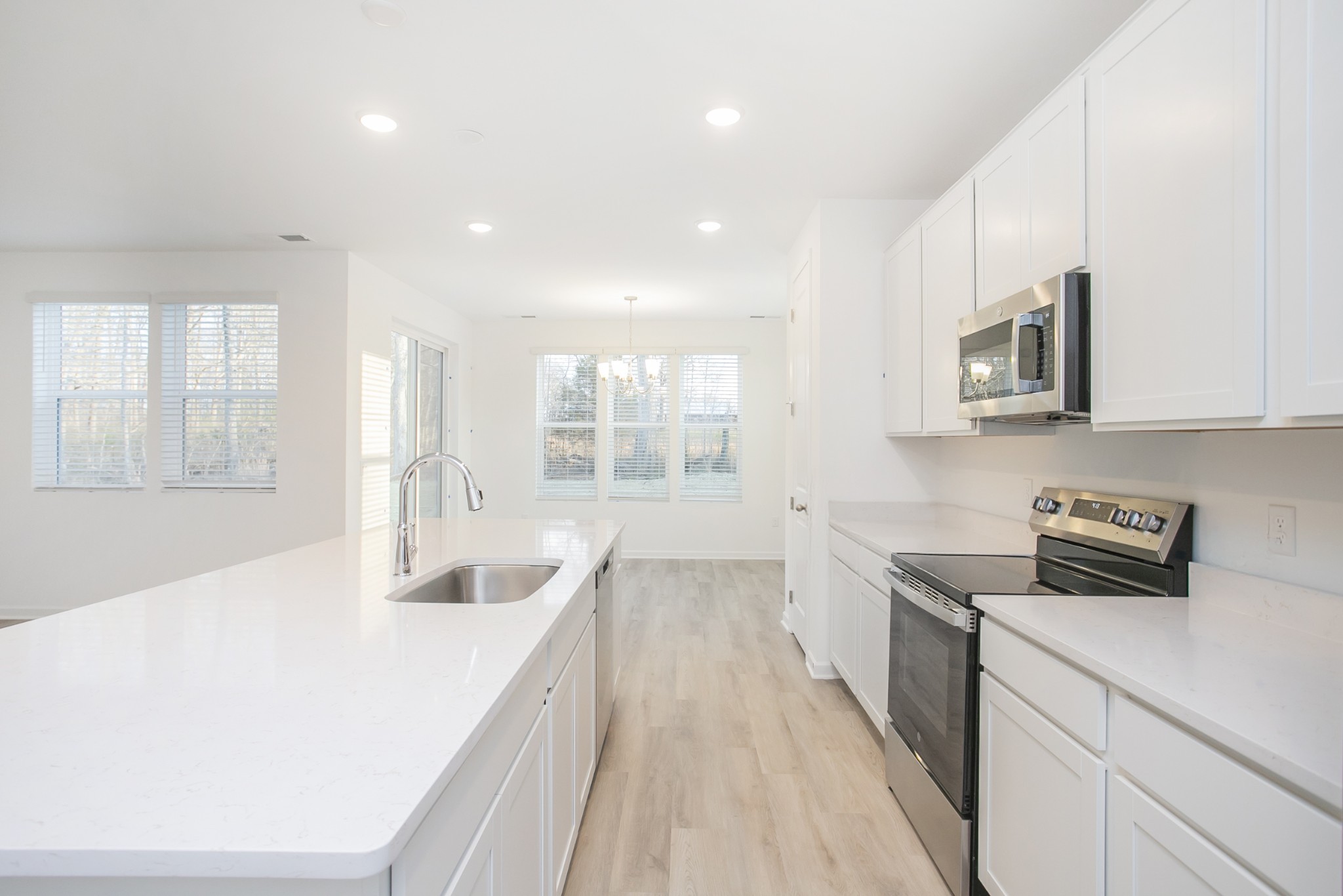 306 Hickory Pointe Drive Dickson, TN 37055 - Photo 27 of 36 a large white kitchen with stainless steel appliances granite countertop a stove a sink dishwasher and a microwave oven with white cabinets