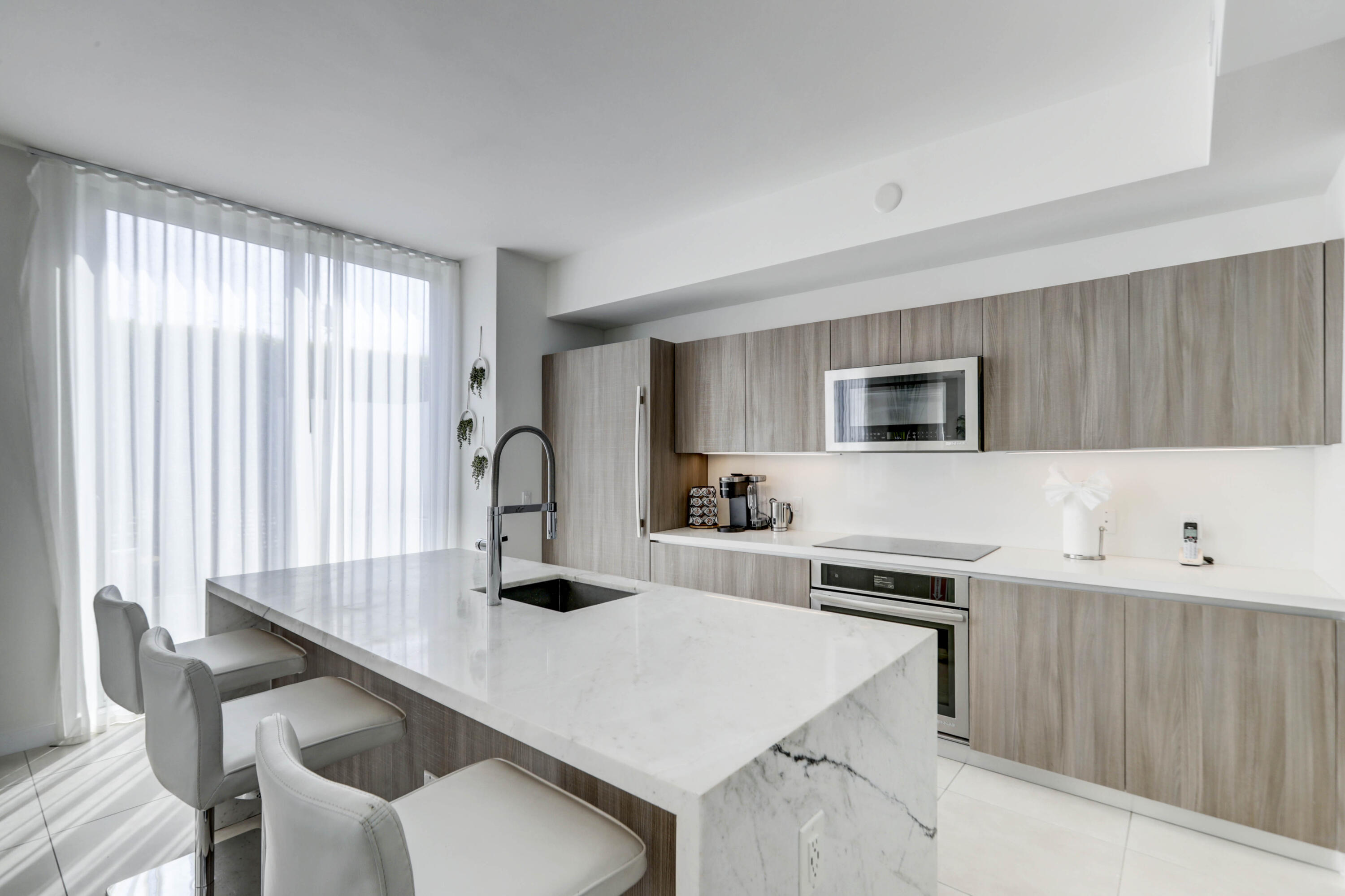 401 North Birch Road, Unit TH3 Fort Lauderdale, FL 33304 - Photo 13 of 49 a kitchen with a table chairs a sink dishwasher window and cabinets