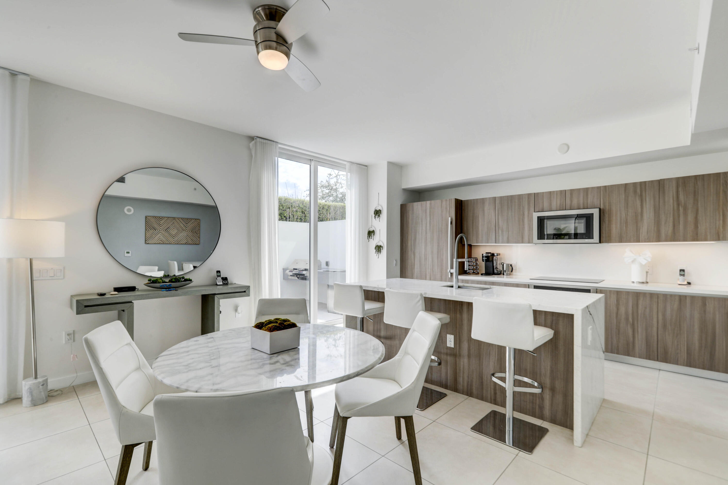 401 North Birch Road, Unit TH3 Fort Lauderdale, FL 33304 - Photo 16 of 49 a kitchen with a dining table chairs and white cabinets