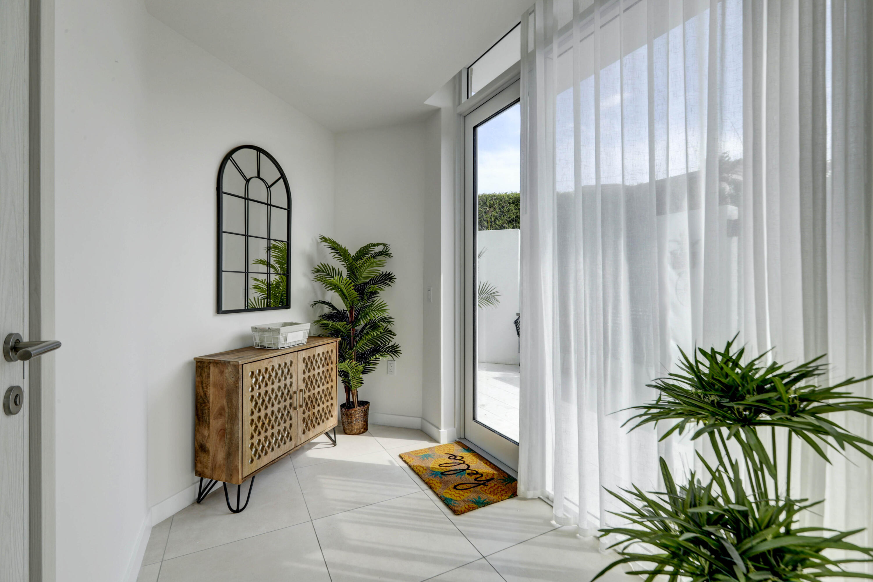 401 North Birch Road, Unit TH3 Fort Lauderdale, FL 33304 - Photo 5 of 49 a living room with a potted plant and a large window