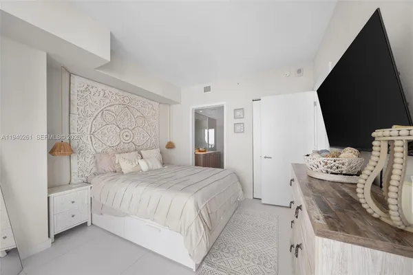 a bedroom with a bed and a flat screen tv