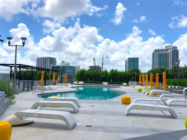 a view of a swimming pool with a bench and yard in the back