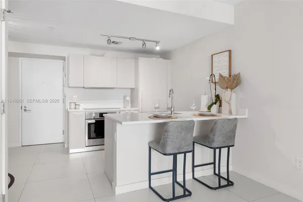 a kitchen with a table chairs refrigerator and cabinets