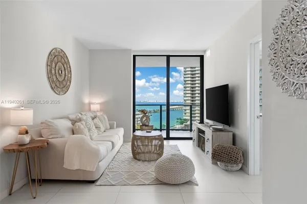 a living room with furniture a flat screen tv and a large window