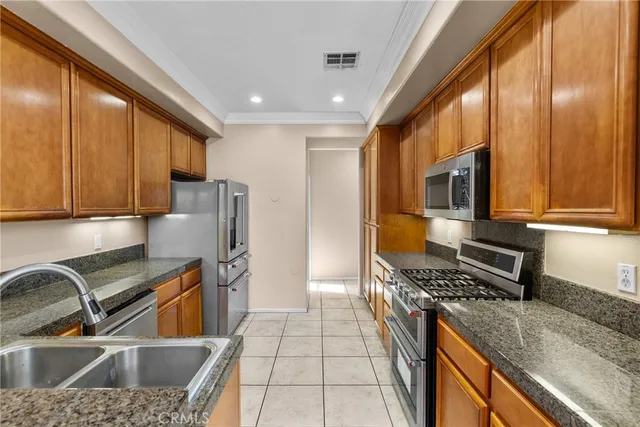 a kitchen with stainless steel appliances granite countertop a refrigerator and a sink