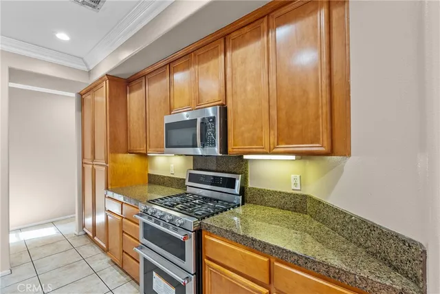 a kitchen with granite countertop wooden cabinets and stainless steel appliances
