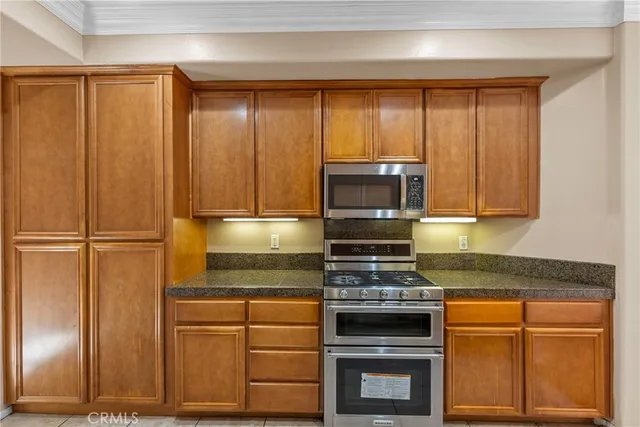 a kitchen with granite countertop a refrigerator and cabinets