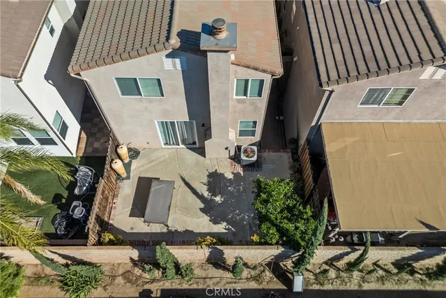 a patio with table and chairs and potted plants