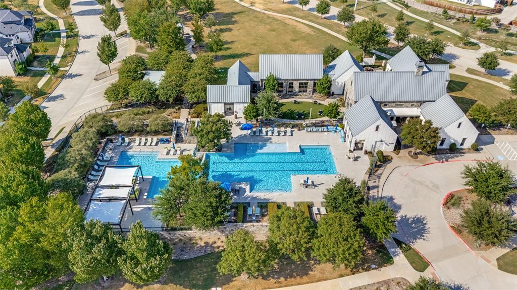 15018 Crape Myrtle Road Frisco, TX 75035 - Photo 33 of 40 Expansive outdoor pool with multiple lounging areas, shaded pergolas, and adjacent recreational building with stone and siding exterior