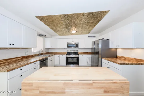 a large kitchen with stainless steel appliances granite countertop a stove and a sink