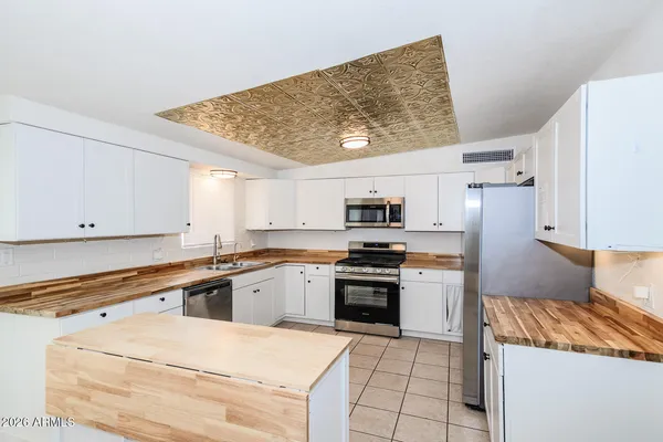 a kitchen with stainless steel appliances granite countertop a sink and white cabinets