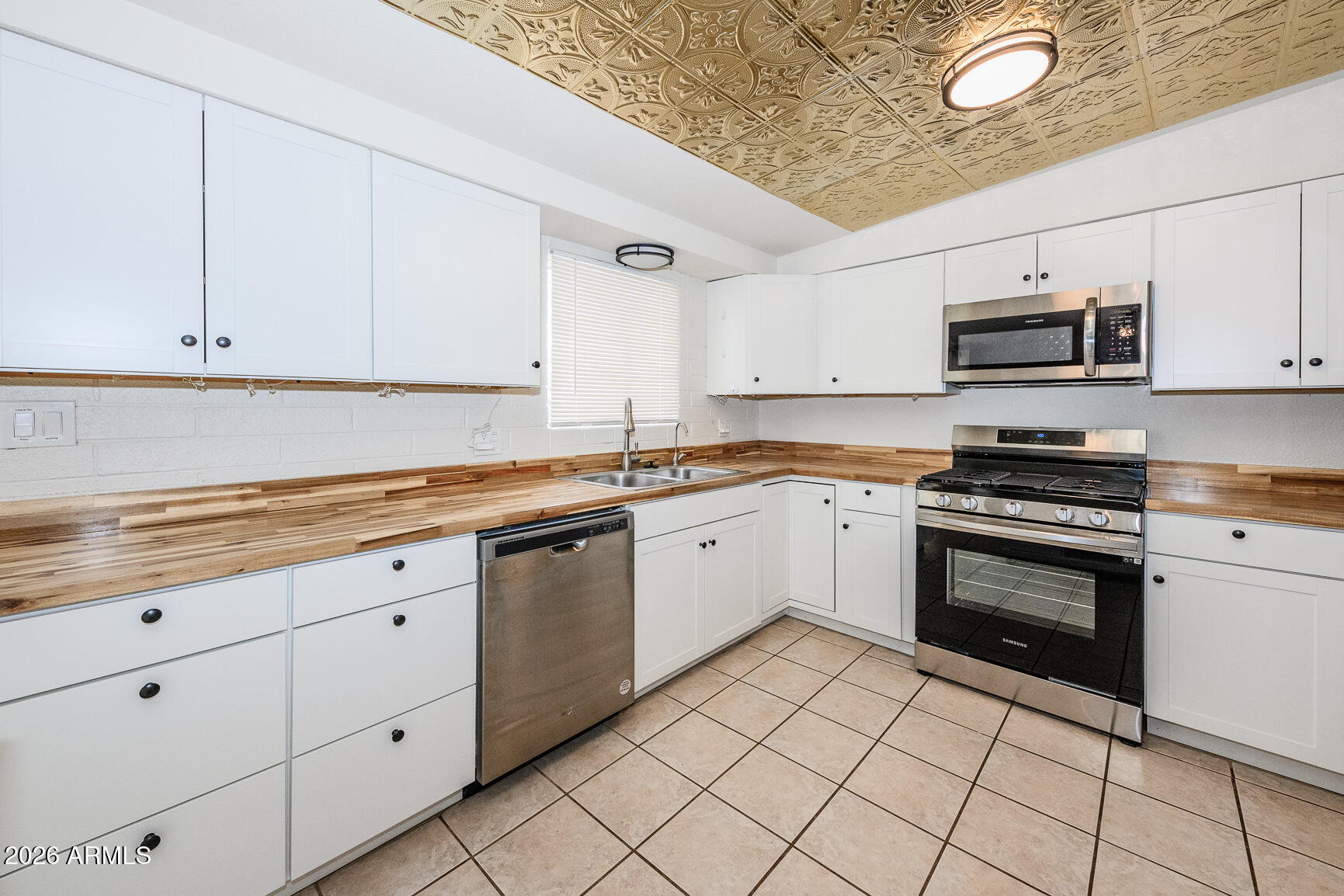 310 2nd Street Huachuca City, AZ 85616 - Photo 16 of 43 a kitchen with granite countertop white cabinets and stainless steel appliances