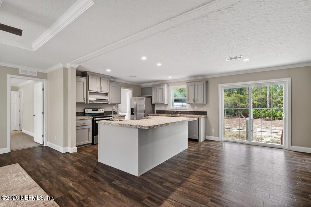 95605 Springhill Road Fernandina Beach, FL 32034 - Photo 11 of 62 a kitchen with stainless steel appliances kitchen island wooden cabinets and wooden floors