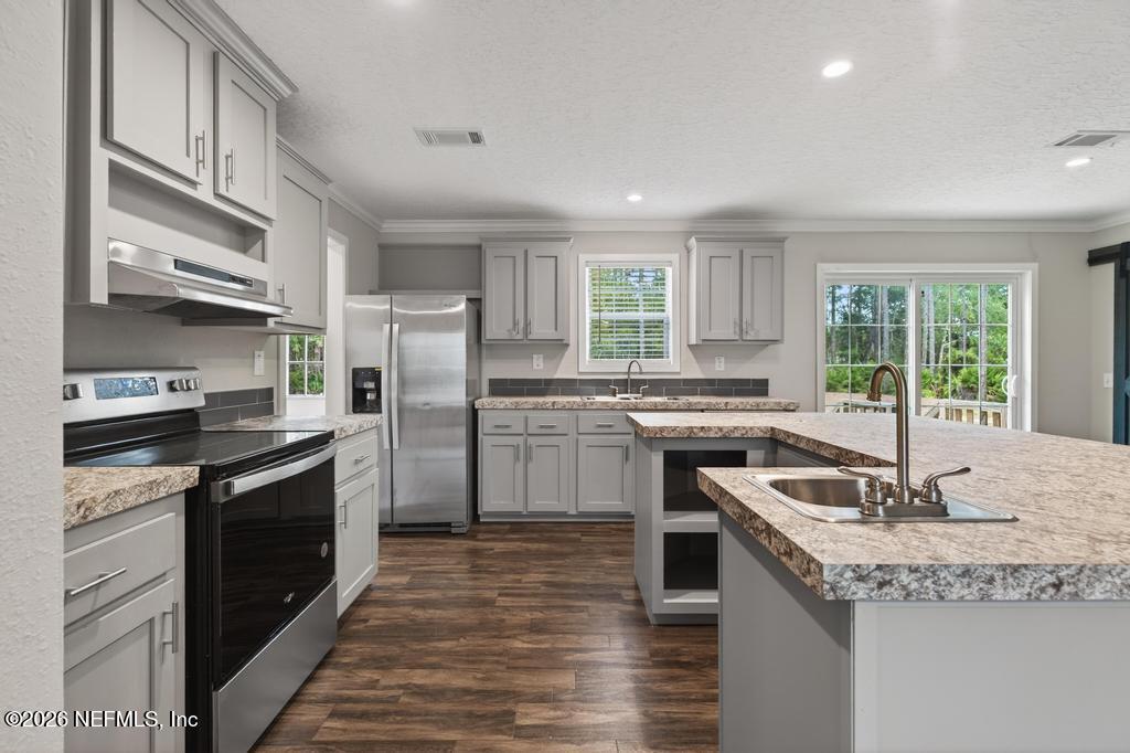 95605 Springhill Road Fernandina Beach, FL 32034 - Photo 12 of 62 a kitchen with granite countertop kitchen island stainless steel appliances a stove sink and cabinets
